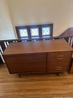 Front view of walnut credenza showing overall form, tambour section and drawers