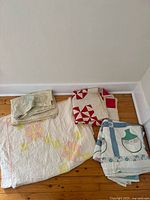 Four folded quilts showing distinct patterns and colors