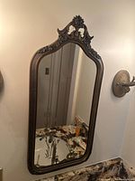 Full view of framed wall mirror mounted above vanity