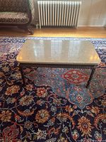 Full view of coffee table on rug showing marble top and base