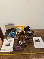 Overall view of all cameras, manuals, accessories on table
