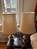 Pair of brass lamps with shades on side table