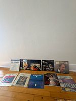 Group shot of all 10 records standing against wall