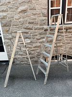 Both aluminum step ladders standing side by side showing overall form