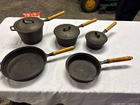 Overview of all five cookware pieces and three lids