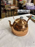 Copper kettle with ceramic handle and knob shown on tabletop