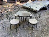 Full set showing table and four chairs outdoors