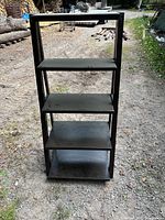 Front view of entire wooden shelf showing four main shelves plus top