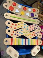 Full view of wooden sensory boards and connectors showing colors, shapes, and missing peg