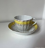 Cup nested on saucer, showing yellow and gold decoration