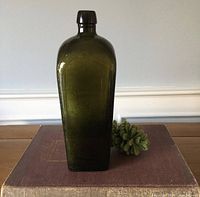 Front view of dark green square gin bottle