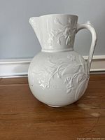 Front view of white ironstone jug with floral relief