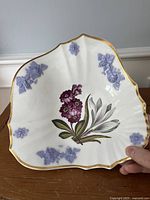 Full dish showing fan shape, floral painting, gilded rim