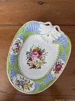 Top view of porcelain dish showing handle, floral art and patterns