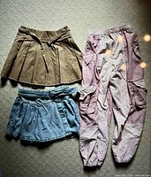 Three bottoms: tan skirt, denim skirt, pink cargo pants