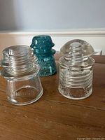 Front view of three glass insulators showing shapes and colours