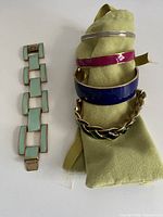 All five bracelets grouped: three bangles, two link bracelets