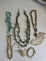 Top view showing all seven necklaces and one bracelet