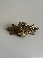 Front view showing gold-tone leaves, faux pearls and rhinestones