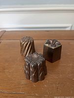 Front view of three antique copper molds