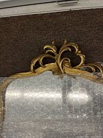 Top crest of gold gilt wooden mirror with scrolling motifs