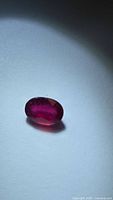 Oval blood red ruby on white background