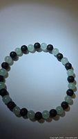 Full view of bracelet showing alternating green aventurine and black lava stone beads