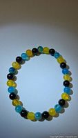 Full view of gemstone bead bracelet showing alternating blue, yellow and black beads