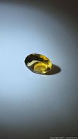 Oval golden citrine gemstone on neutral background