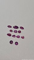 Group of 11 faceted rubies on neutral background