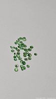 Cluster of approx. 35 small round green tsavorite garnets