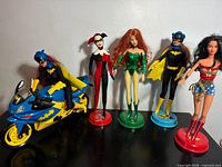 Group shot of all dolls and Batcycle