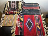 Overall view of four woven rugs on table