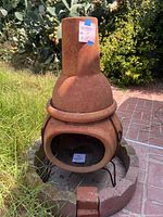 Front view of terracotta chiminea inside stone base