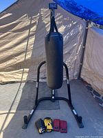 Overall view of Everlast heavy bag on stand with gloves at base