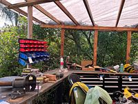 Workbench with bench vise, combination sander, vacuum and fasteners visible