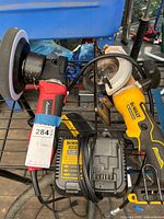 Overall view showing Avid Power buffer, Dewalt circular saw and charger together on rack