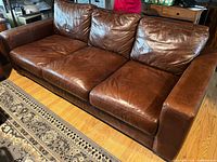 Full view of brown leather 3-seat sofa front angle