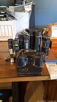 Group of flashlights and Bushnell monocular on table