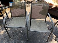 Two woven patio armchairs side-by-side on deck