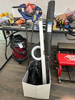 Box with telescoping pole, ring light, clamps, ground sheet and bag visible