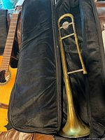 Trombone in open plush-lined soft case on couch