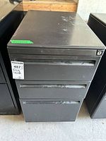Front view of dark grey Haworth 3-drawer filing cabinet with MaxSold tag