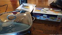 GE electric skillet with lid, Elite Gourmet burner box, Starfrit Pro Mandolin box on table