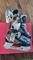 Adult CCM JetSpeed FT455 skates on red box with blade guards visible