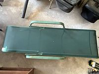 Top view of green sling chaise lounge showing full length and arms