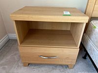 Front view of nightstand showing drawer, open shelf, feet