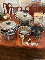 All items on table: Carrera saucepans, stockpots, cake pan, two sev sancha presses and discs