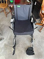 Front view of wheelchair showing seat, armrests, footrests