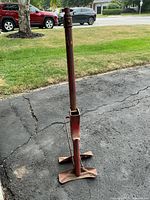 Front upright view of red metal farm jack showing overall form